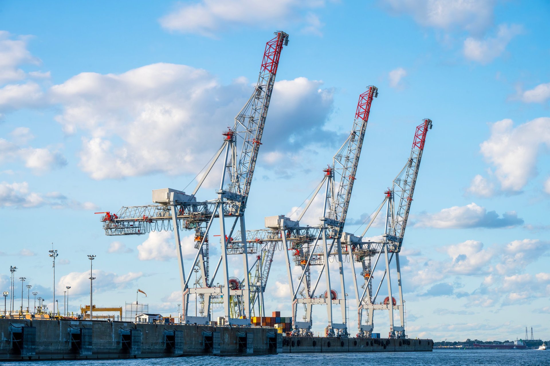 Port cranes working over a quay where reinforcement and construction materials are landed
