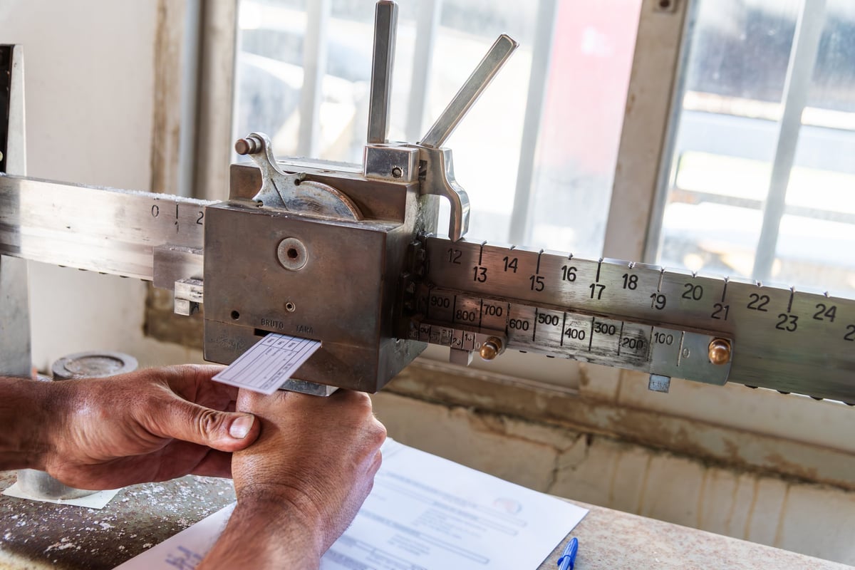 Bundle of equal-section billets being counted and weighed on an industrial platform scale.