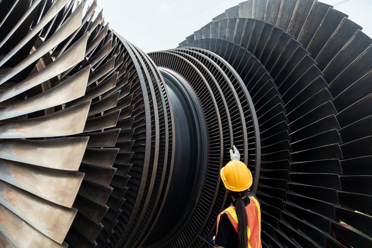 Engineer inspecting power plant turbine equipment in a high-temperature plant