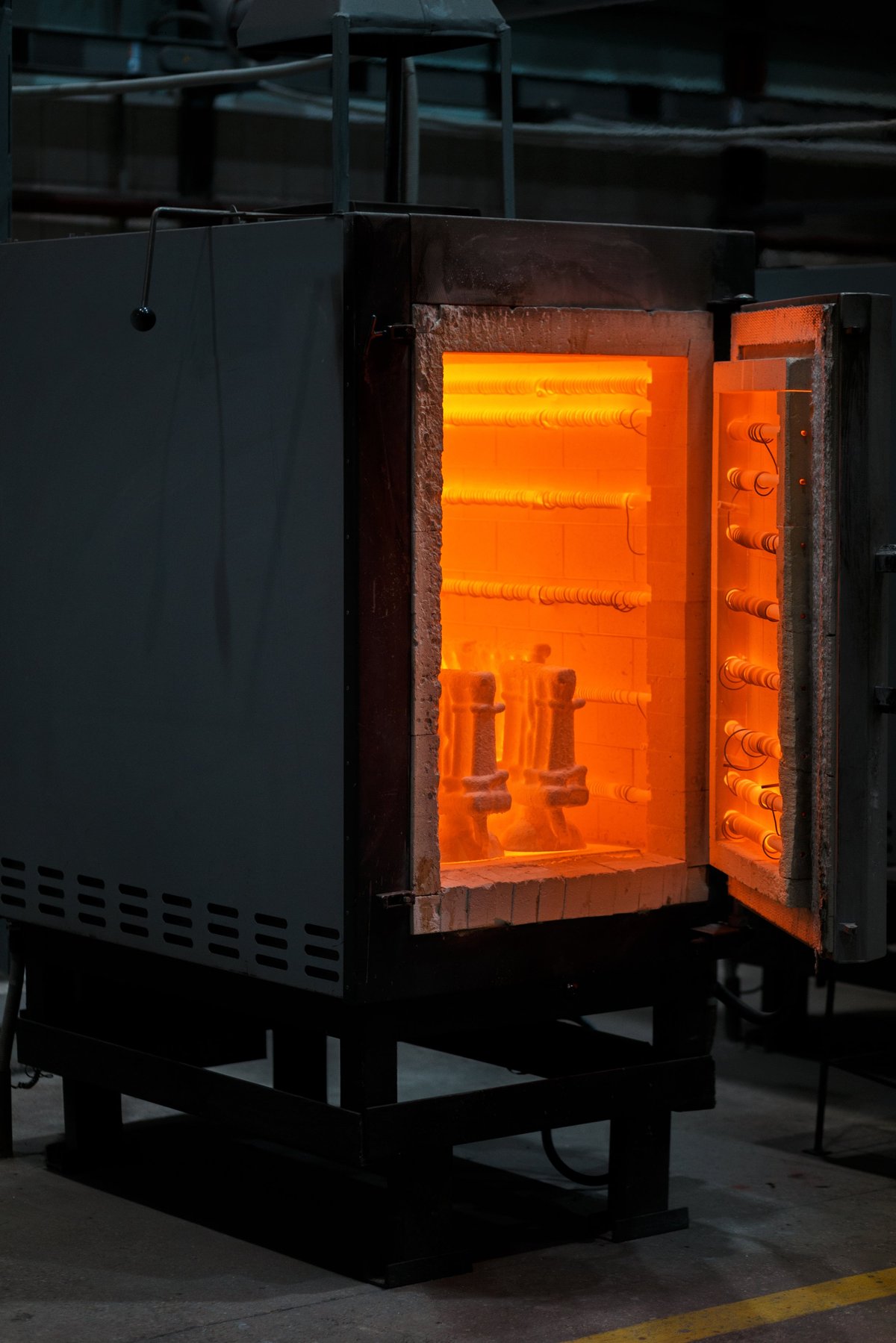 Red-hot billet entering a bar-mill roughing stand under controlled heat-lot routing.