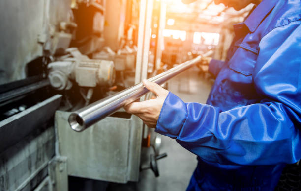 Worker checking metal pipes